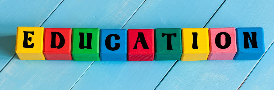 Auf dem Bild ist eine Reihe von bunten Holzwürfeln mit Buchstaben zu sehen, die zusammen das Wort "education" (Bildung) ergeben.