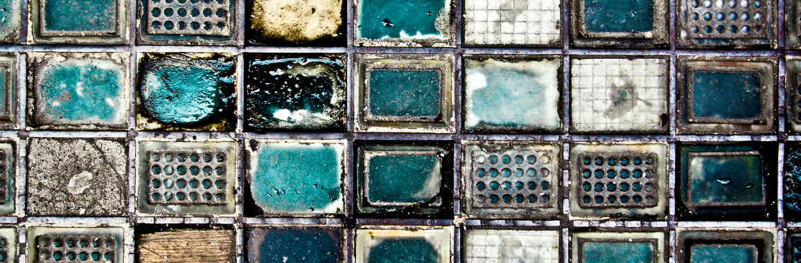 Das Bild zeigt Glasbausteine überwiegend in Grau und Türkis.